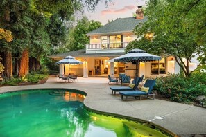 A two-story house with a swimming pool, outdoor seating area, and a well-maintained garden. - Best Chico luxury experience. (Chico)