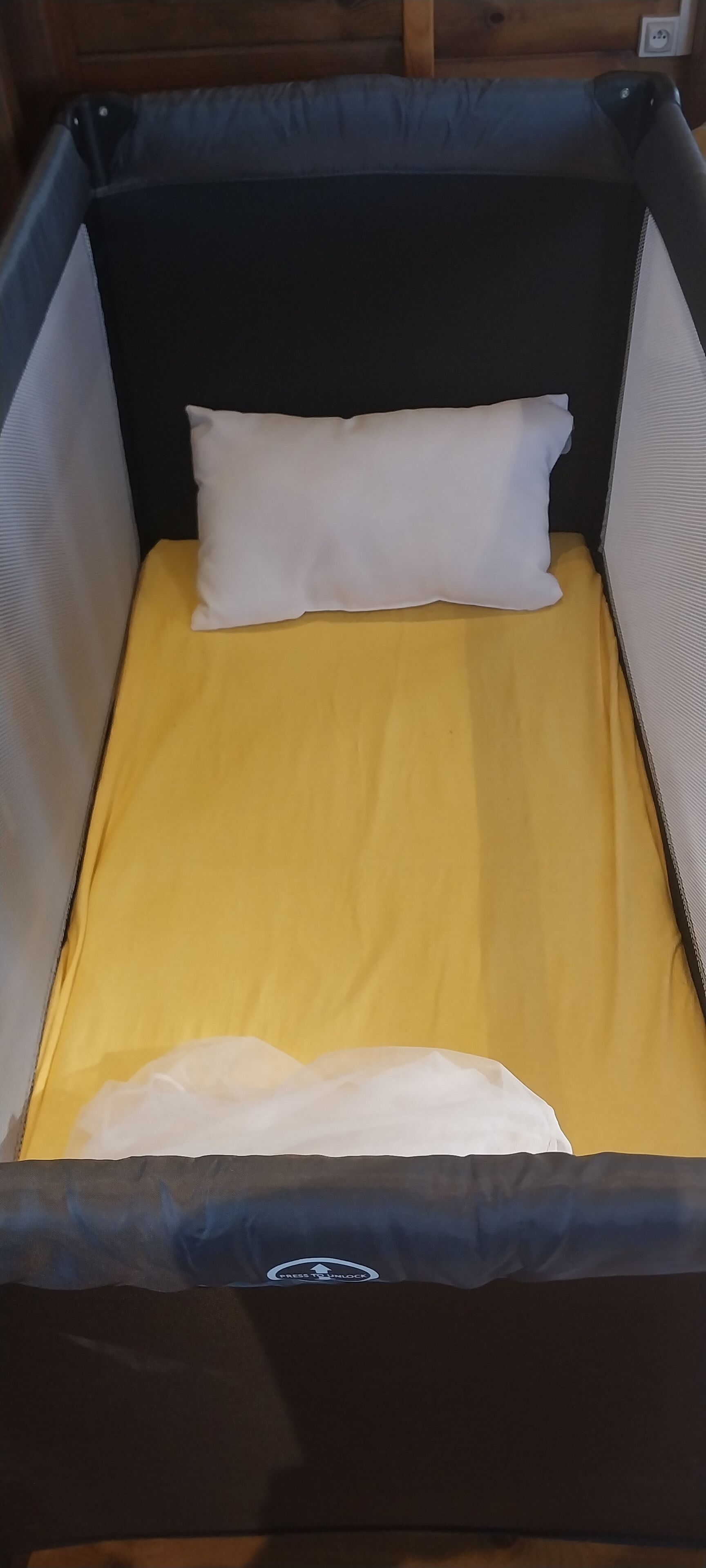 A compact, enclosed sleeping area with a yellow mattress and a white pillow.