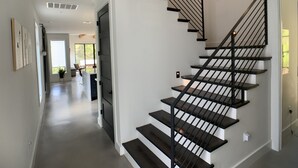 A modern interior with a staircase leading to a second floor. - Treetop Modern Oasis Lakeway (Austin)