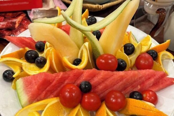 A plate of assorted fruits including watermelon, oranges, and blueberries.