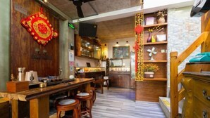A wooden bar area with stools, a counter, and a staircase with a wooden railing. - Xiang Xie Li She Inn (Shenzhen)