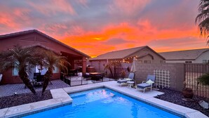A backyard with a swimming pool, outdoor furniture, and a sunset sky. - Chandler Oasis Pool, Golf Views & Fire Pit (Chandler)
