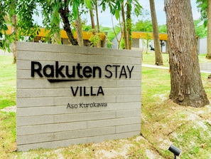 A sign for Rakuten Stay Villa with a brick wall and text indicating the name and location.
