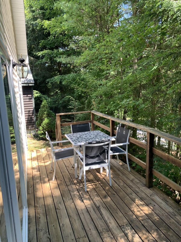 Enjoy an outdoor space with a table and chairs surrounded by lush greenery.