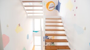 Una escalera con escalones de madera y una pared blanca con formas abstractas de colores, y un logotipo que dice 'Five Stars'.