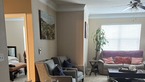 A dining area with a round table set for four, surrounded by chairs. There is a sofa and a coffee table in the background. - Cozy, Cool & Central location to the Galleria and NRG stadium (Houston)