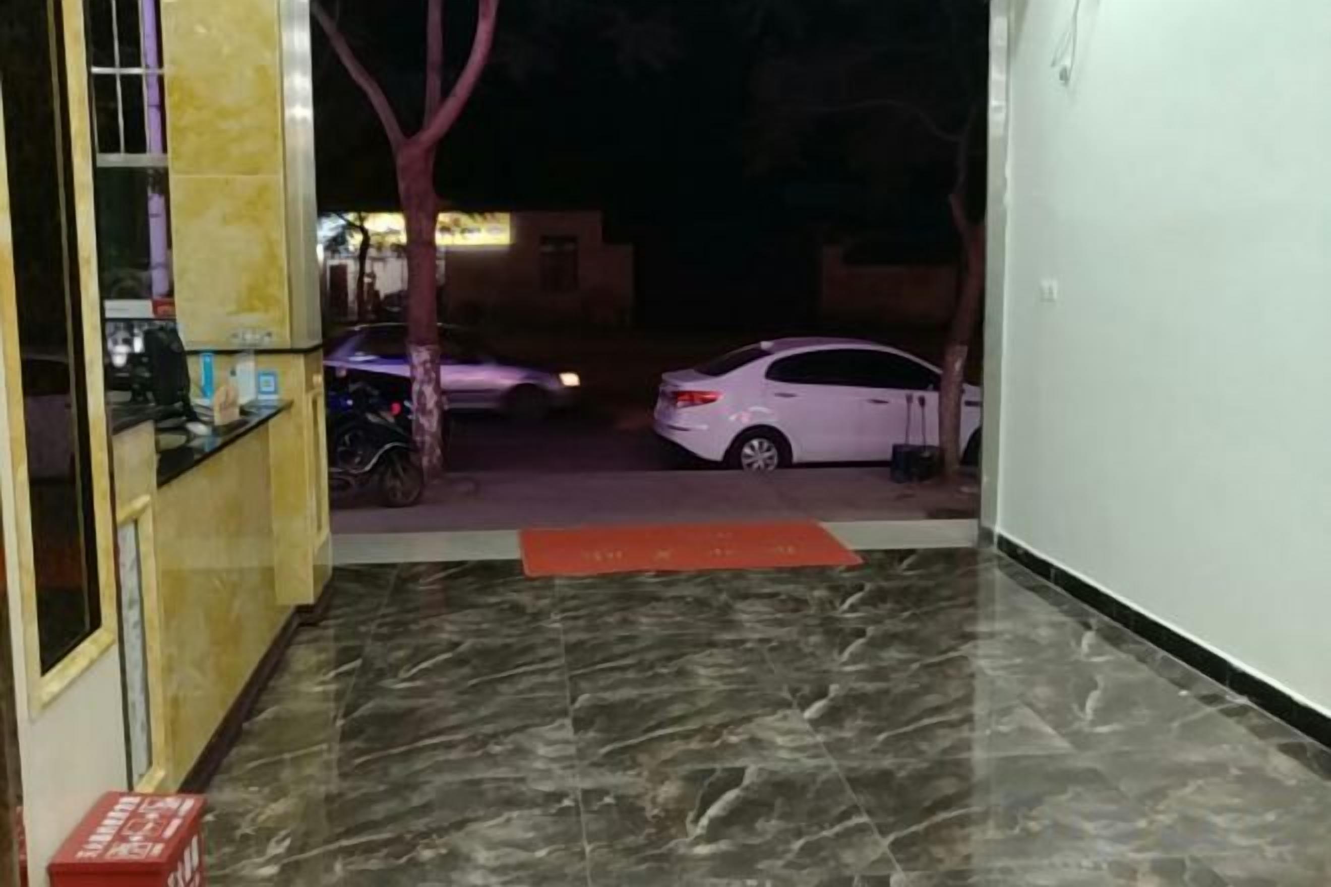 A hallway with a marble floor leading to a parking area.