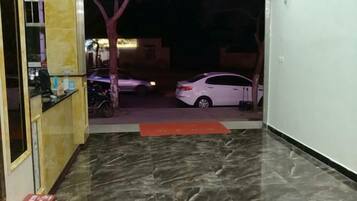 A hallway with a marble floor leading to a parking area.