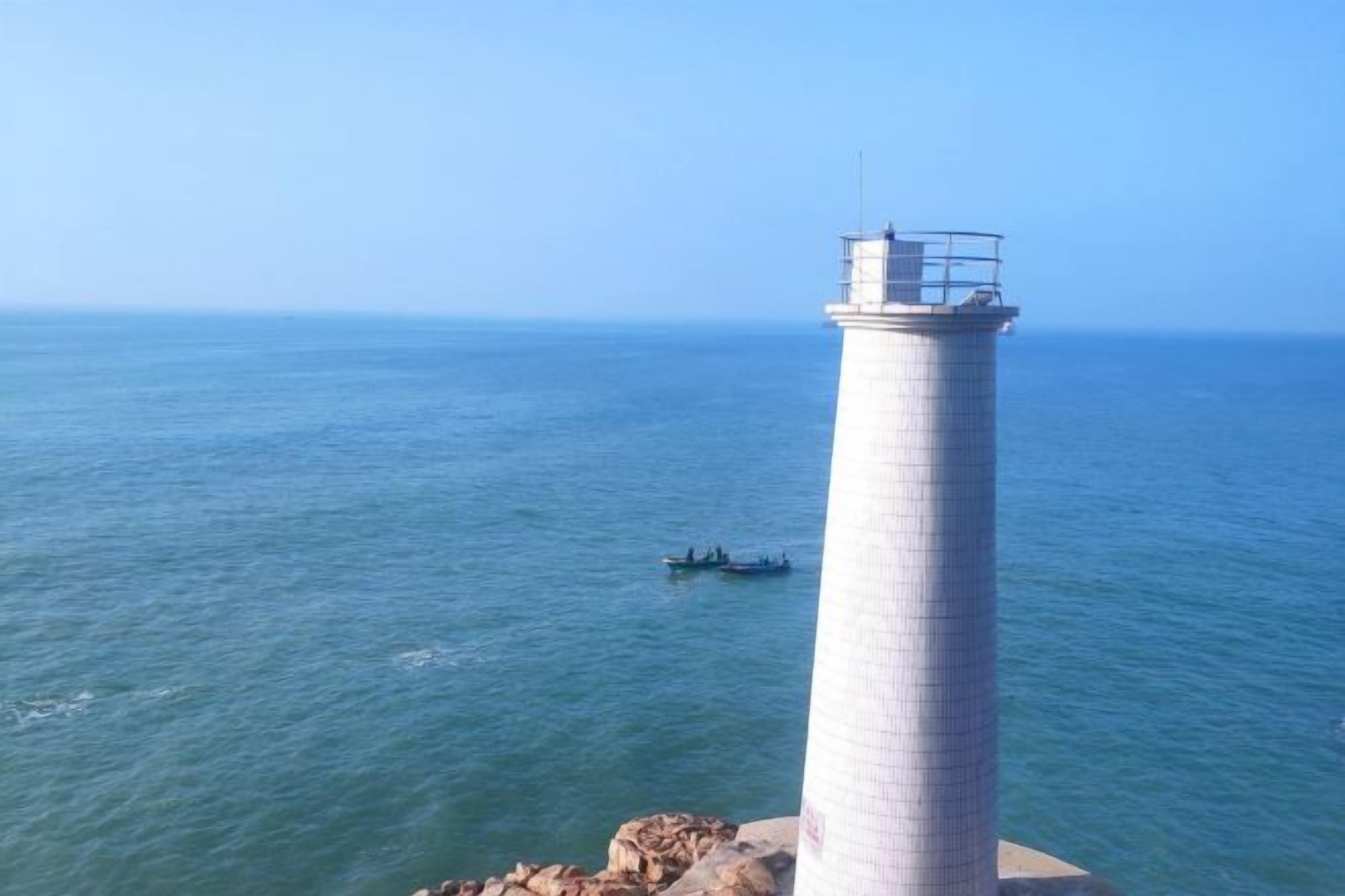 A lighthouse by the sea with a clear view of the ocean.