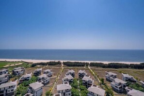 A coastal residential area with modern houses arranged in rows, a beach in the background, and a clear sky. - Lantian Weekend Vacation Homestay (Yangjiang Hailing Island Poly Silver Beach) (Yangjiang)