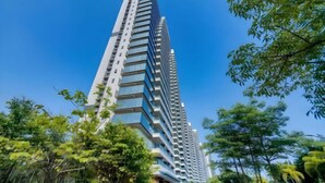A tall, modern building with a glass facade and multiple balconies. - Lantian Weekend Vacation Homestay (Yangjiang Hailing Island Poly Silver Beach) (Yangjiang)