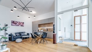A modern living room with a dining area, a kitchen, and a large window. - Beautiful 1BR Apartment with Paid Parking by EasyBNB Premium (Prague)