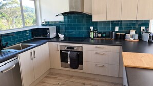 Een moderne keuken met een ingebouwde oven, een magnetron en een spoelbak.