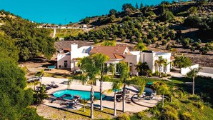 A modern villa with a swimming pool, surrounded by lush greenery and hills. - Grapevine by Avantstay Secluded 5BR Villa 4 Acres of Vineyards & Avo Groves! (Temecula)