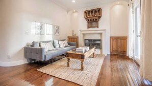 A living room with a grey sofa, wooden coffee table, and a fireplace.