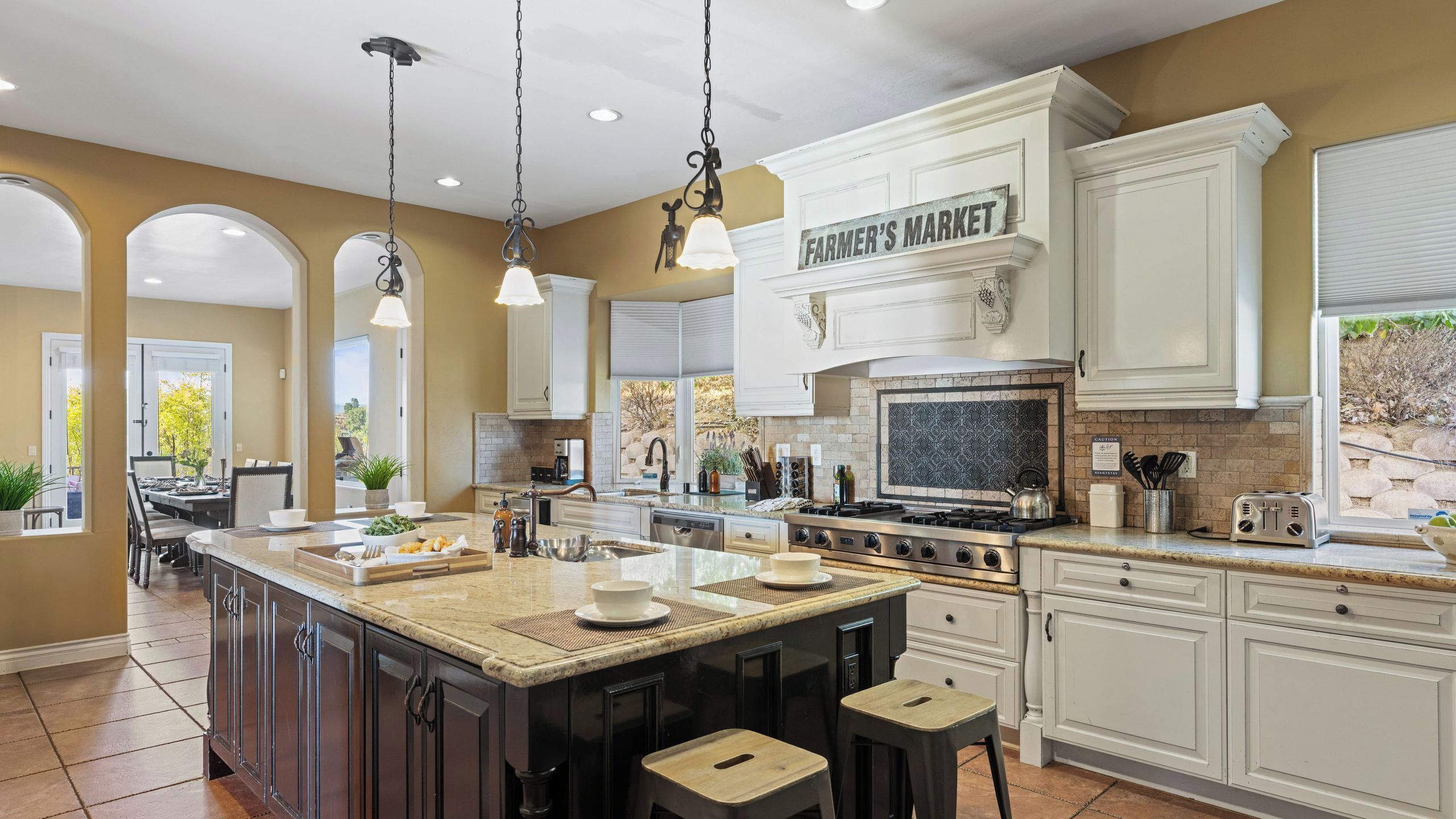 A spacious kitchen with a large island, white cabinetry, and a farmhouse-style design.
