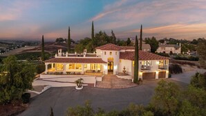 A large, two-story house with a spacious driveway and a well-maintained lawn. - Wine Country Villa Large Rooftop Terrace w/ Views + Game Room Via del Sur (Temecula)