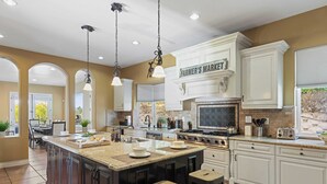 A spacious kitchen with a large island, white cabinetry, and a farmhouse-style stove. - Wine Country Villa Large Rooftop Terrace w/ Views + Game Room Via del Sur (Temecula)