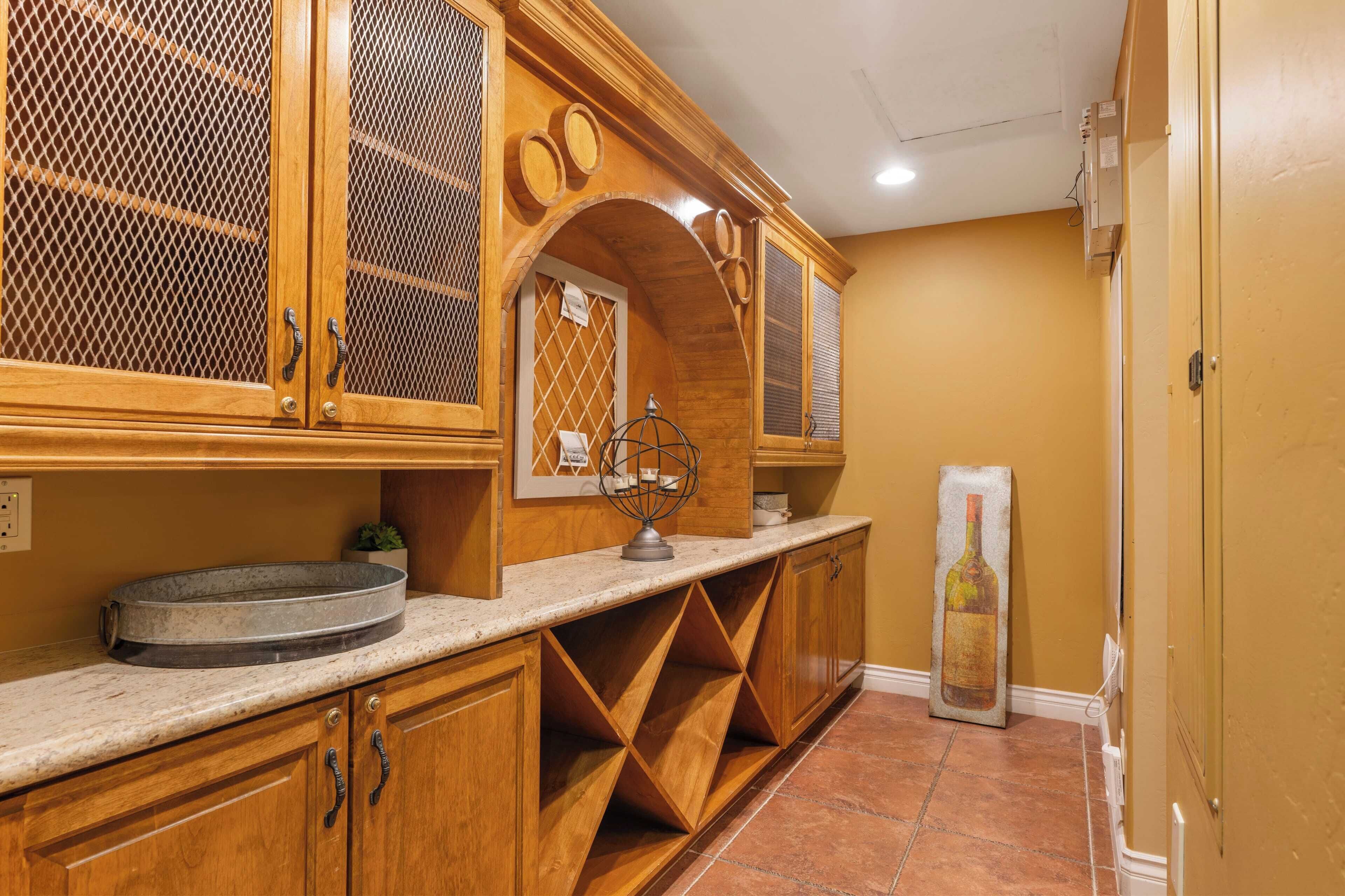 A kitchen with wooden cabinets, a sink, and a decorative bottle sculpture.