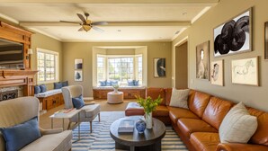 A spacious living room with a fireplace, comfortable seating, and large windows. - Willow by Avantstay Mountain Views - See Hot Air Balloons From Pool (Temecula)