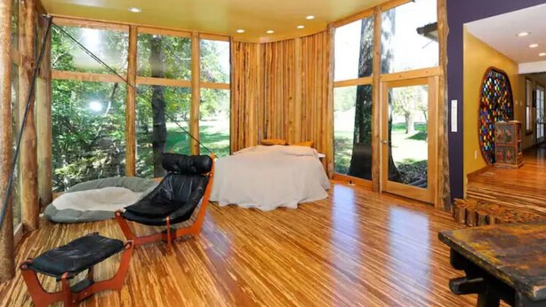 A spacious room with a large bed, a chair, and a table.