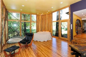 Una habitación amplia con una cama grande, una silla y una mesa.