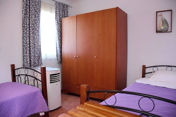 A bedroom with a bed, a wardrobe, a desk, and a chair.