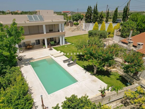 A residential property with a swimming pool, a covered patio, and a view of the surrounding neighborhood. - Blue Sky Villa in Crete (heraklion)