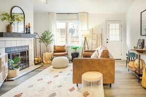 A modern living room with a fireplace, comfortable seating, and a view of the outdoors. - Modern ranch, stylish hidden 💎 in the most convenient U-MED DISTRICT!  (Anchorage)