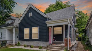 A two-story house with a dark exterior, a front porch, and a visible pink door. - The Pink Pearl / 5 Min to Rupp / Newly Remodeled (Lexington)