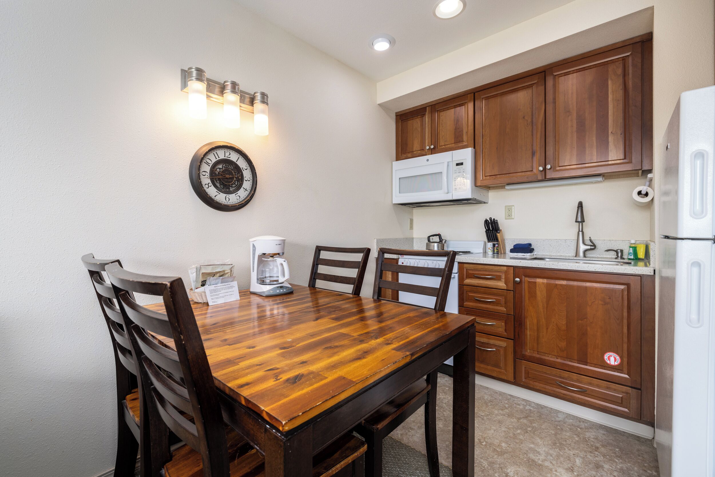 Una cocina con armarios de madera, microondas y cafetera.