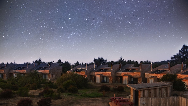 Una hilera de cabañas bajo un cielo estrellado.