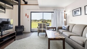 Una sala de estar moderna con un sofá, una mesa de centro, un televisor y una chimenea.