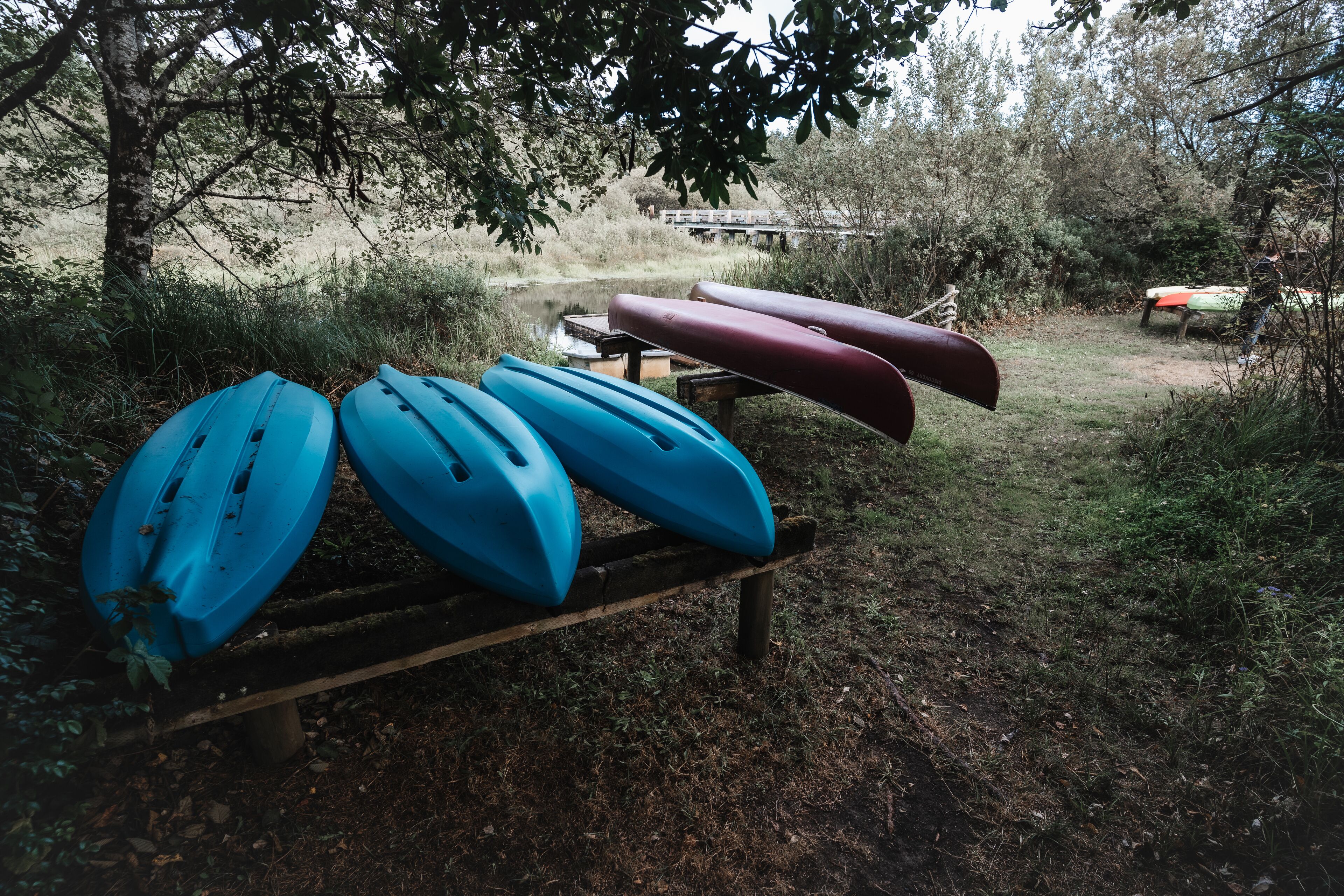 Un banco de madera con varias kayaks alineadas.