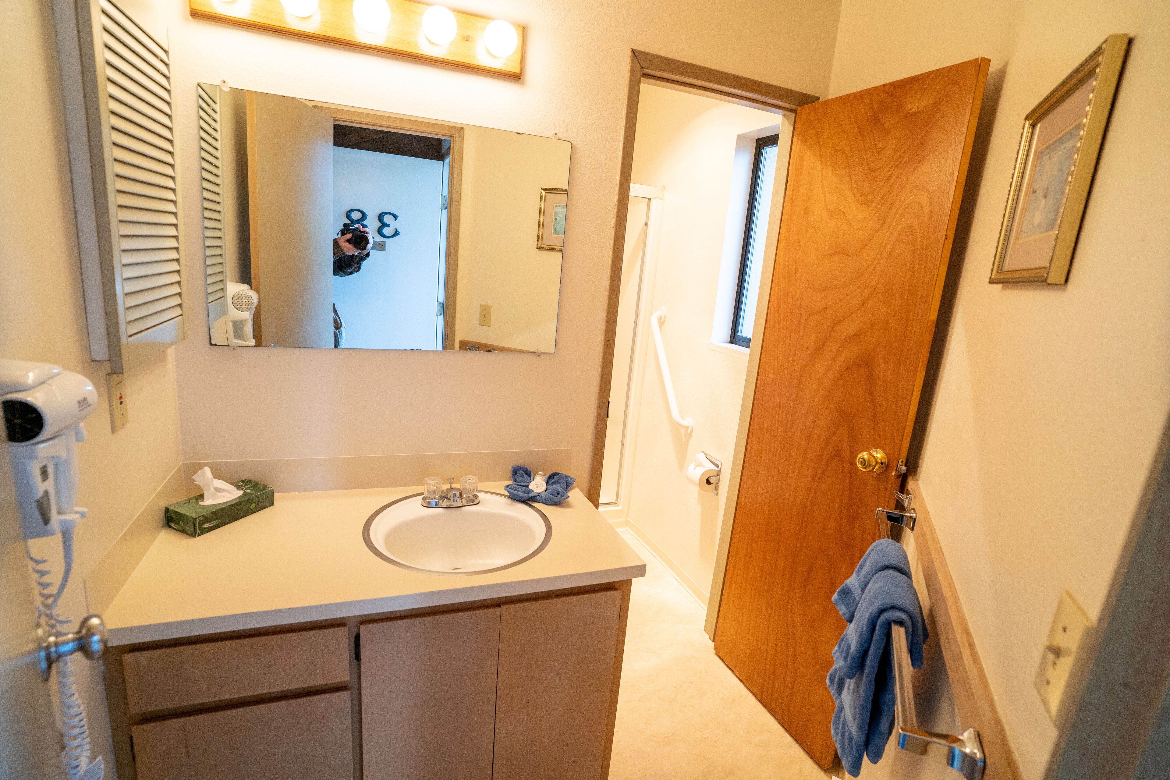 Une salle de bain équipée d’un lavabo, d’un miroir et d’un porte-serviettes.