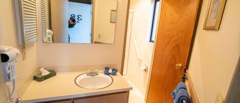Une salle de bain équipée d’un lavabo, d’un miroir et d’un porte-serviettes.