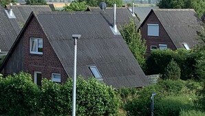 Zona residencial con casas de tejados inclinados, antenas parabólicas y una calle con topes.