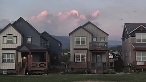 Three houses with distinct architectural styles, a wooden deck, and a clear view of the surrounding landscape. - the Sunset House - modern comfort with spectacular views (Leadville)