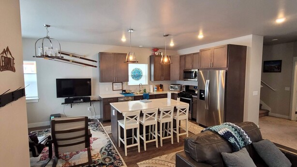A modern kitchen with a central island, built-in appliances, and pendant lighting. - the Sunset House - modern comfort with spectacular views (Leadville)