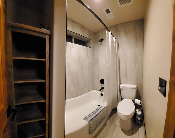 A compact bathroom with a bathtub, toilet, and shower curtain. - Luxurious farmhouse industrial design. Private HotTub, relax with gorgeous views (garden city)