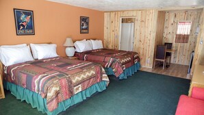 A room with two beds, a desk, and a chair.