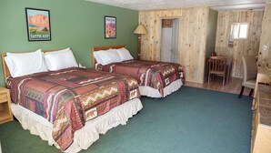 A room with two beds, a wooden door, a chair, and a green carpet. - 0131) Candy Suite 131 (Sevier)