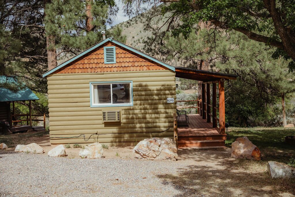 A small cabin with a porch, a window, and a number "106" on the door.