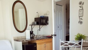 A compact living space with a kitchenette, a dining area, and a white couch.