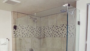 A glass-enclosed shower with a tiled floor and a checkered pattern on the lower wall. - T-0001) Missouri Pacific (Sevier)