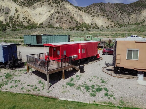 A train station with a red caboose, a blue caboose, and a beige caboose. - T-0001) Missouri Pacific (Sevier)
