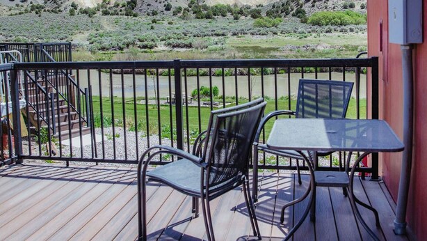 A deck with a table and chairs, overlooking a mountainous landscape. - T-008) The Cotton Belt (Sevier)
