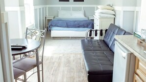 A compact room with a bed, a small dining table, a sofa, and a kitchenette. - T-09) Southern Pacific (Sevier)