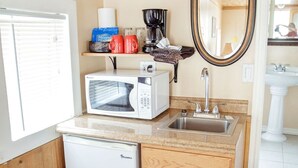 Une petite cuisine équipée d’un four à micro-ondes, d’une machine à café et d’un petit réfrigérateur.