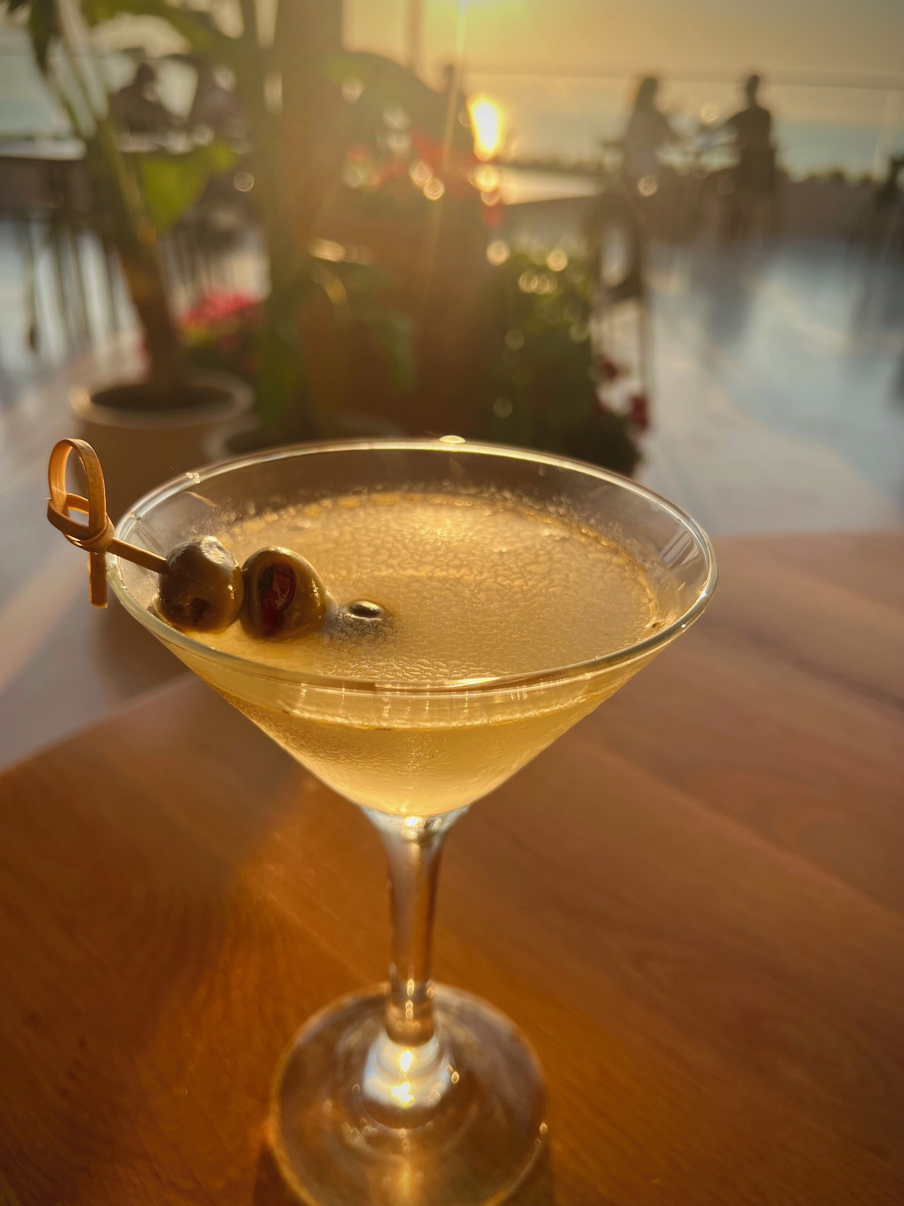 A martini glass with a garnish on a wooden table.